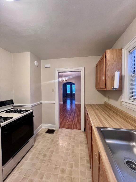 kitchen with sink, range, and a chandelier