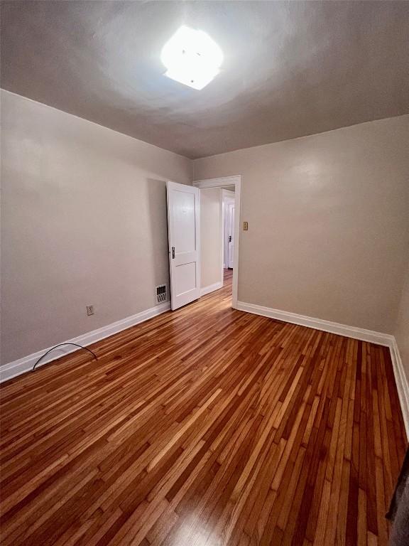 empty room with hardwood / wood-style floors