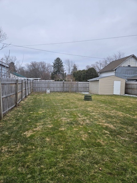 view of yard featuring a storage shed, an outdoor structure, and a fenced backyard