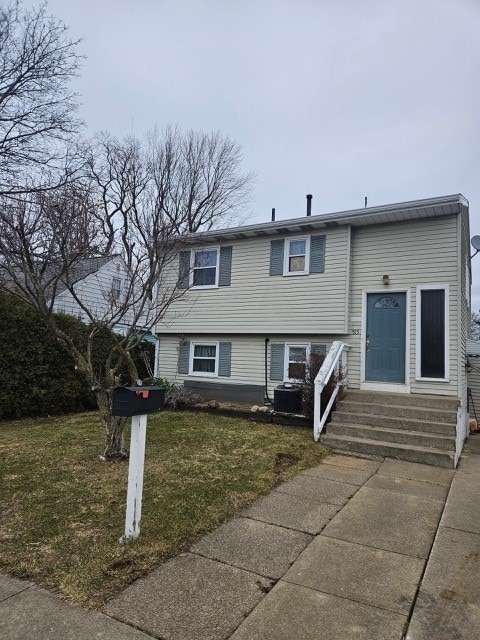 view of front of home with central air condition unit, a front yard, and entry steps