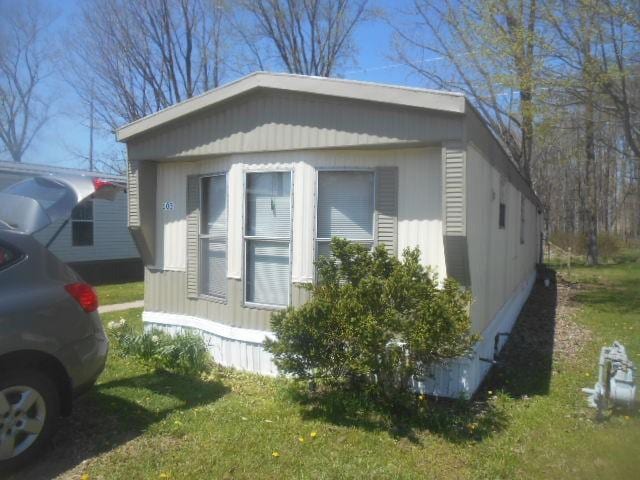 view of side of property with a lawn