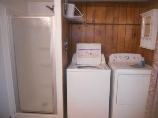 laundry area with washer and dryer, wooden walls, and laundry area