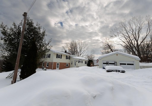 yard covered in snow with an outbuilding and a detached garage