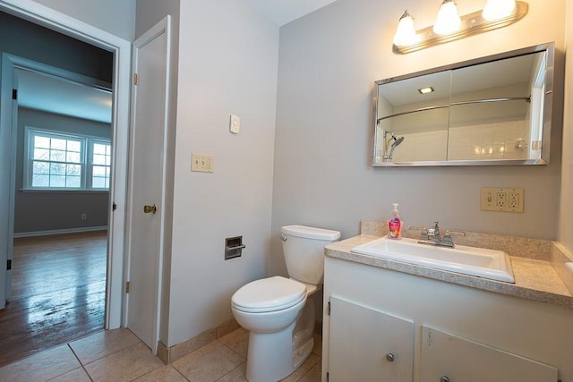 full bath featuring a shower, toilet, vanity, baseboards, and tile patterned floors