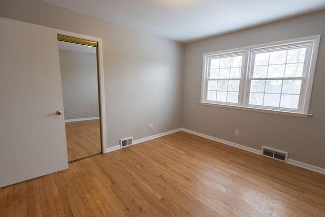 unfurnished bedroom with baseboards, visible vents, and light wood finished floors