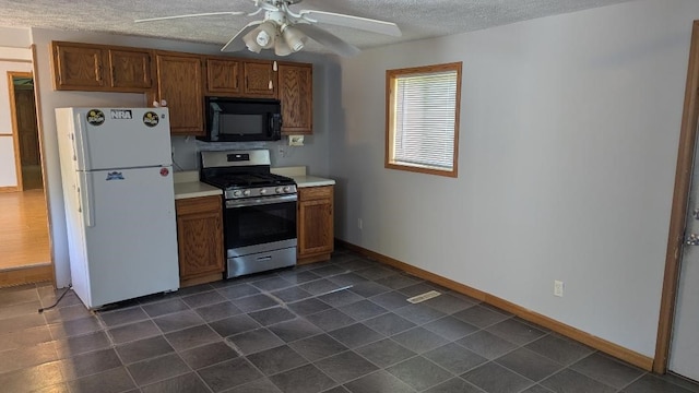 239 Marion St, Corry, PA 16407 - kitchen with black microwave, freestanding refrigerator, stainless steel gas stove, a textured ceiling, and light countertops
