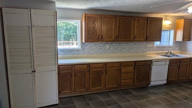 239 Marion St, Corry, PA 16407 - kitchen with white dishwasher, a textured ceiling, light countertops, decorative backsplash, and dark tile patterned floors