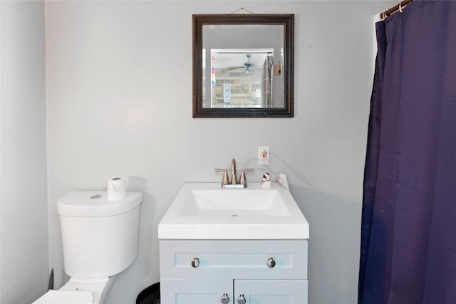 bathroom featuring vanity, curtained shower, and toilet