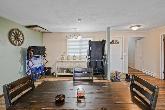 dining room with an inviting chandelier, hardwood / wood-style flooring, a textured ceiling, and baseboard heating