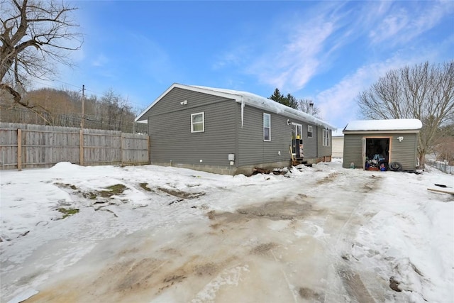 view of snowy exterior with a storage unit