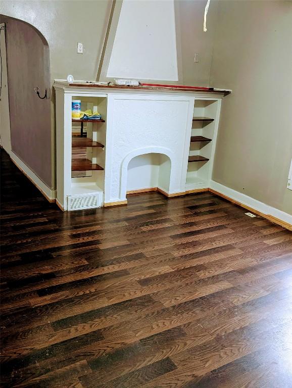 unfurnished living room featuring dark wood-type flooring