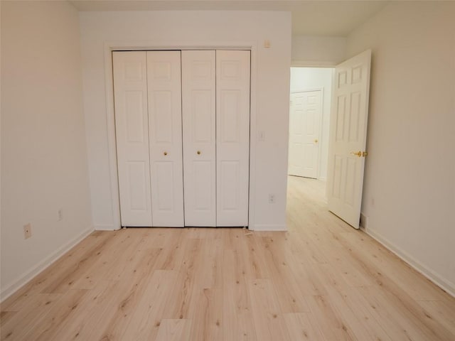 unfurnished bedroom with a closet and light wood-type flooring