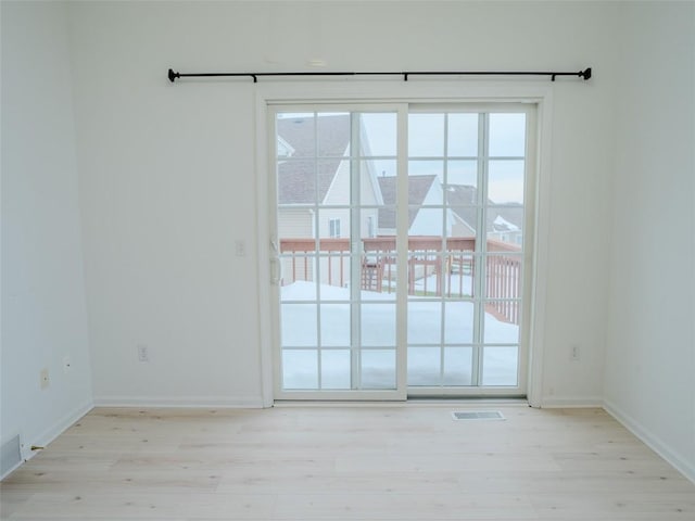 doorway to outside featuring plenty of natural light and light hardwood / wood-style flooring