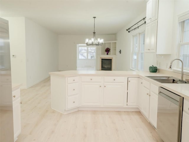 kitchen with sink, white cabinets, stainless steel dishwasher, kitchen peninsula, and light wood-type flooring