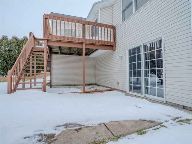 snow covered patio featuring a deck