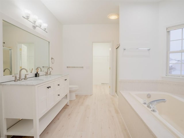 full bathroom featuring hardwood / wood-style flooring, vanity, plus walk in shower, and toilet