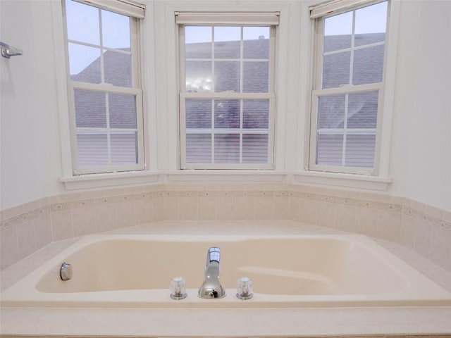 bathroom with a tub to relax in and plenty of natural light