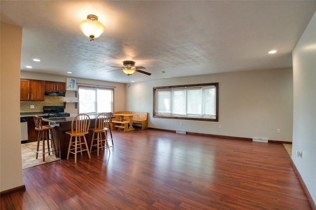 13151 Water Ext, Edinboro, PA 16412 - kitchen featuring brown cabinets, a breakfast bar, dark wood-style floors, a ceiling fan, and stove
