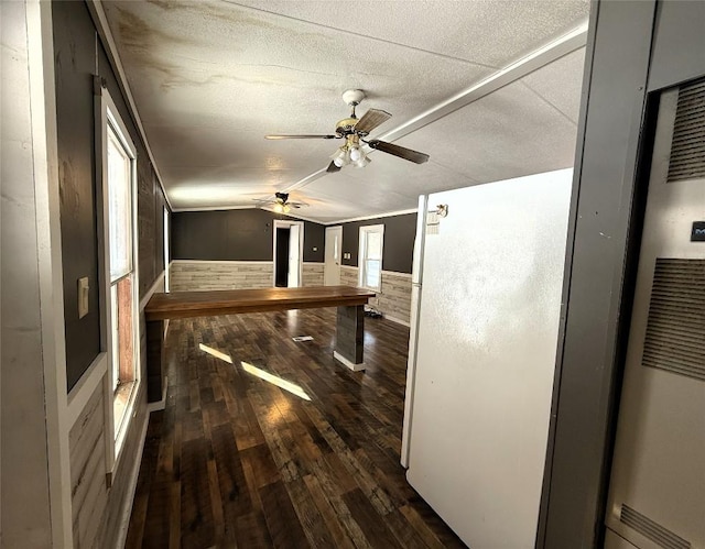 interior space with ceiling fan, lofted ceiling, and dark hardwood / wood-style flooring