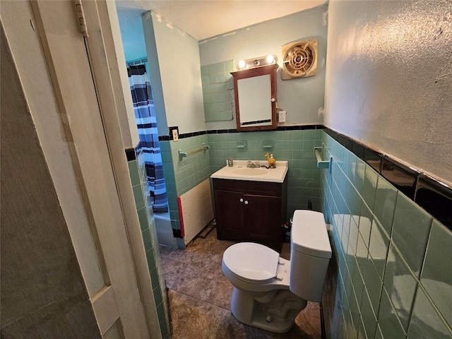 520 E 2nd St, Erie, PA 16507 - full bathroom with vanity, a shower with shower curtain, tile walls, radiator, and a wainscoted wall