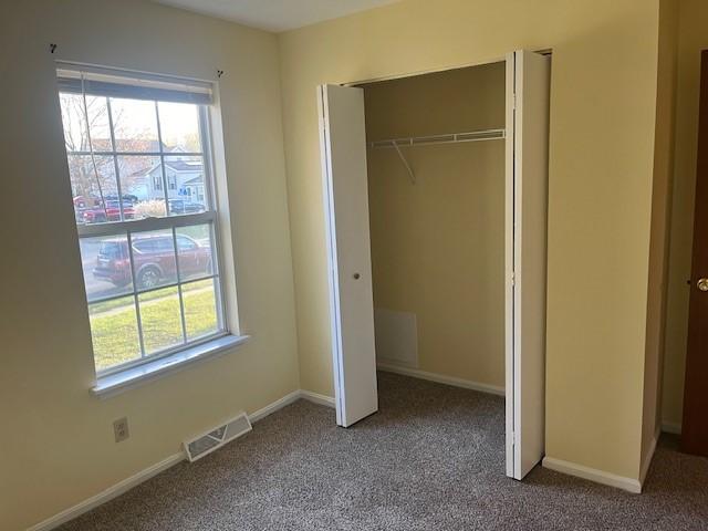 unfurnished bedroom featuring carpet flooring and a closet