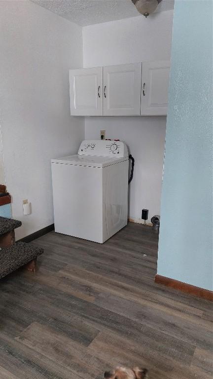 laundry room with dark wood-style floors, cabinet space, a textured ceiling, washer / dryer, and baseboards