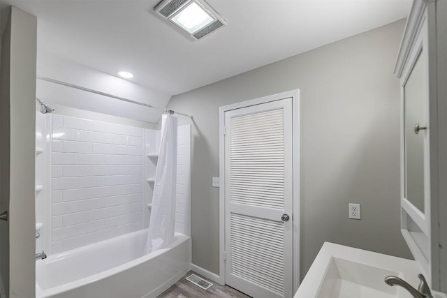 bathroom with hardwood / wood-style floors and shower / tub combo with curtain