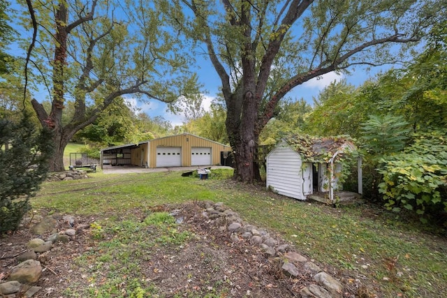 view of yard featuring an outbuilding, a garage, and a carport