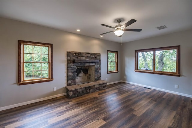 unfurnished living room featuring ceiling fan, a fireplace, and dark wood-type flooring