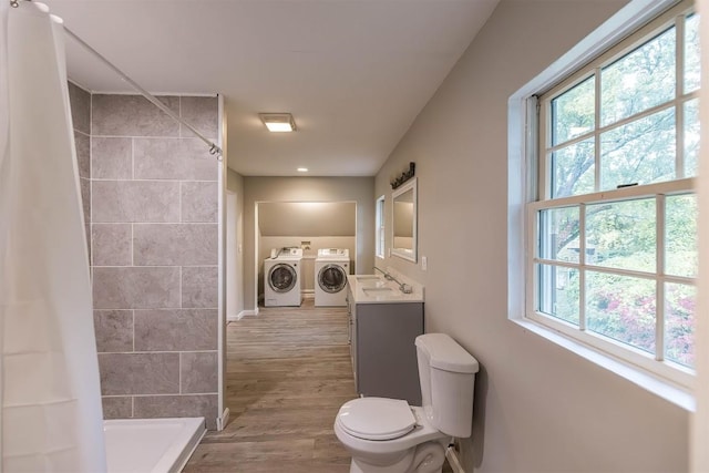 bathroom featuring a wealth of natural light, curtained shower, washer and clothes dryer, and vanity