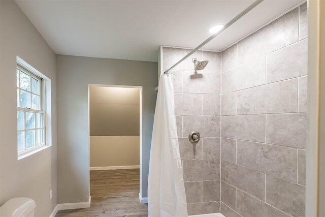 bathroom featuring a shower with shower curtain, toilet, and hardwood / wood-style floors