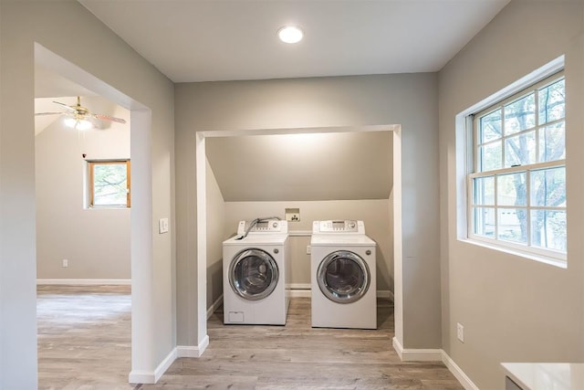 laundry area with ceiling fan, separate washer and dryer, and light hardwood / wood-style flooring