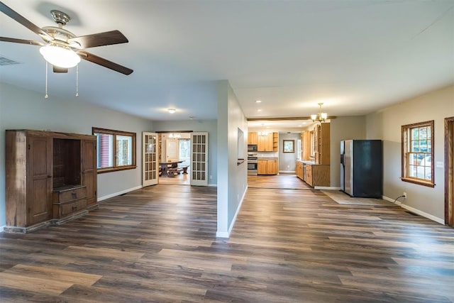 unfurnished living room featuring dark wood-type flooring and ceiling fan with notable chandelier