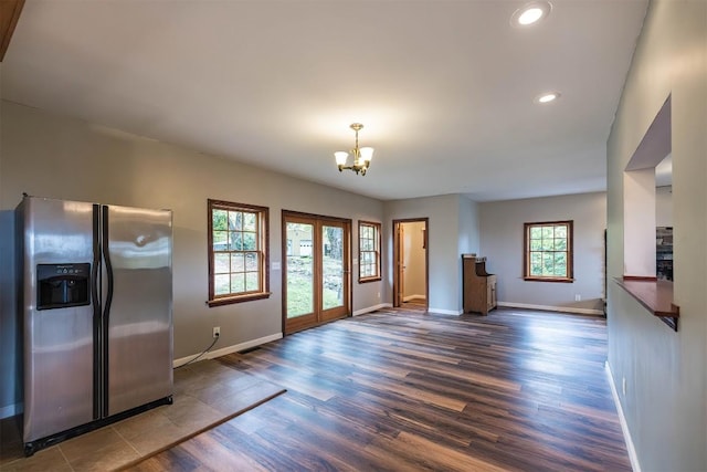 interior space featuring french doors, dark wood-type flooring, stainless steel refrigerator with ice dispenser, a chandelier, and decorative light fixtures