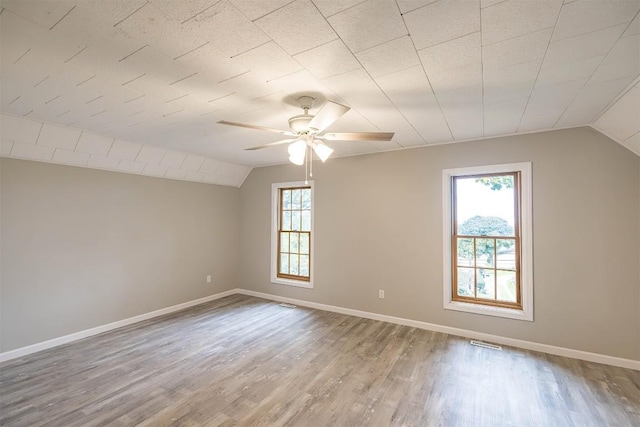 bonus room featuring hardwood / wood-style floors, a wealth of natural light, and vaulted ceiling