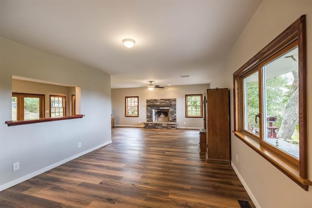 unfurnished living room with a fireplace, dark hardwood / wood-style floors, and ceiling fan