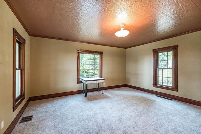 unfurnished room with carpet, ornamental molding, and a wealth of natural light