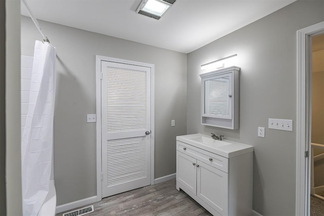 bathroom featuring hardwood / wood-style floors, vanity, and shower / tub combo with curtain