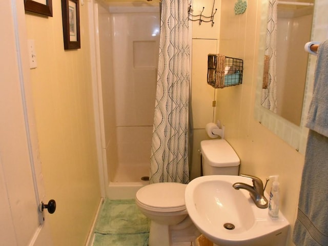 bathroom with curtained shower, toilet, and sink