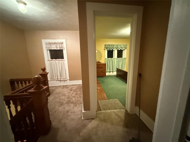 hall featuring carpet and an upstairs landing