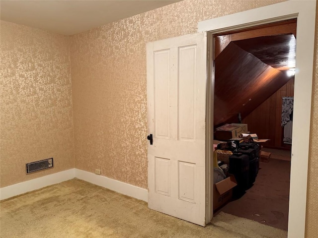 interior space with carpet floors, wallpapered walls, baseboards, and visible vents