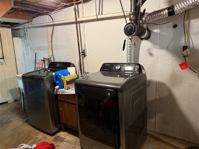 clothes washing area with washing machine and dryer