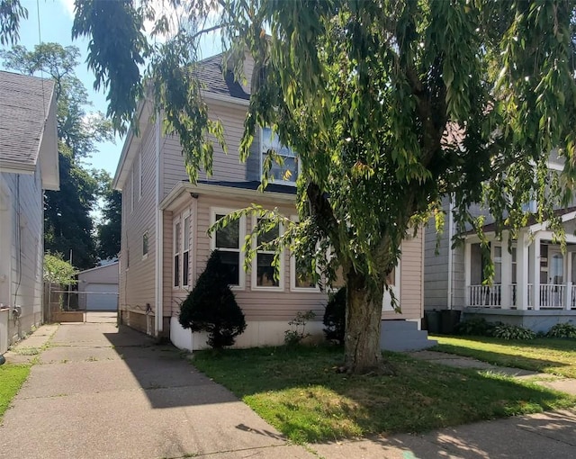 obstructed view of property featuring an outbuilding, a garage, and a front lawn