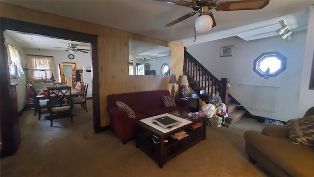 living room featuring ceiling fan and wood walls