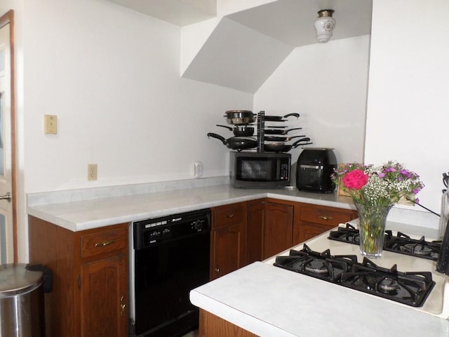 kitchen featuring brown cabinets, light countertops, dishwasher, and gas range