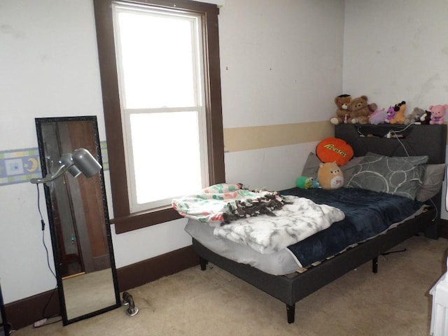 bedroom with baseboards and light colored carpet