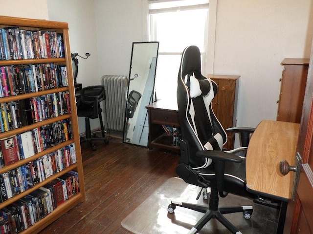 home office with radiator heating unit and dark wood finished floors