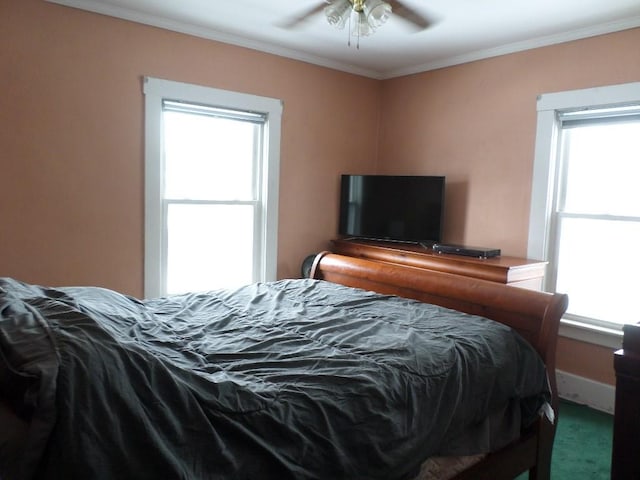 carpeted bedroom featuring ornamental molding, a ceiling fan, and baseboards