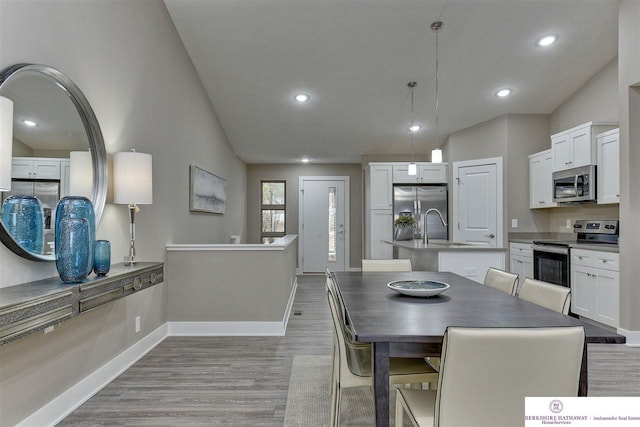 dining space with sink and light wood-type flooring