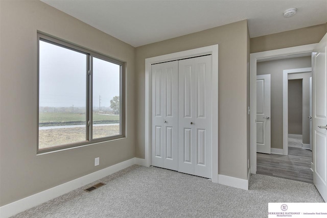 unfurnished bedroom featuring a closet and light carpet